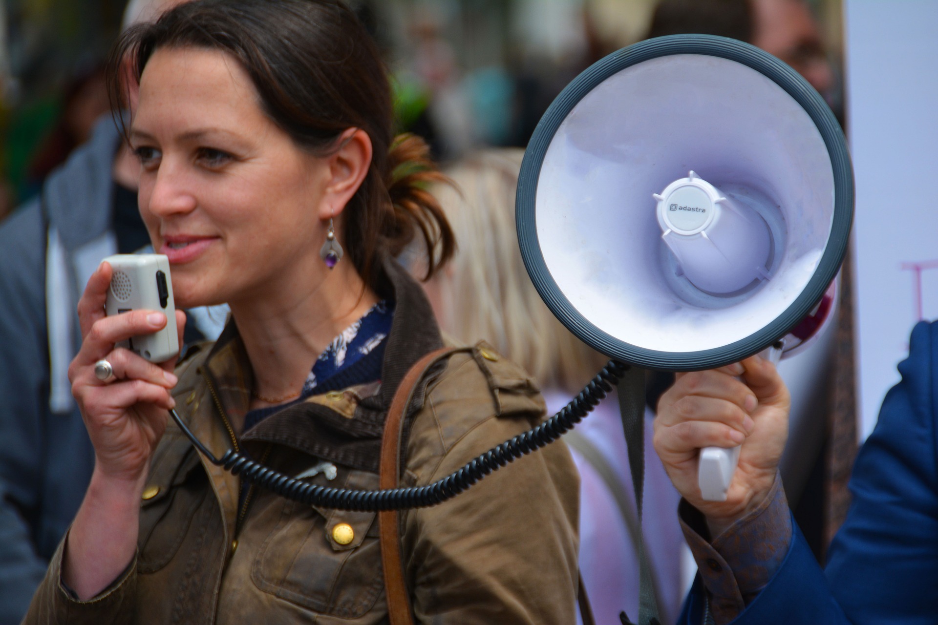 Eine spricht während einer Demonstration in ein Megafon.