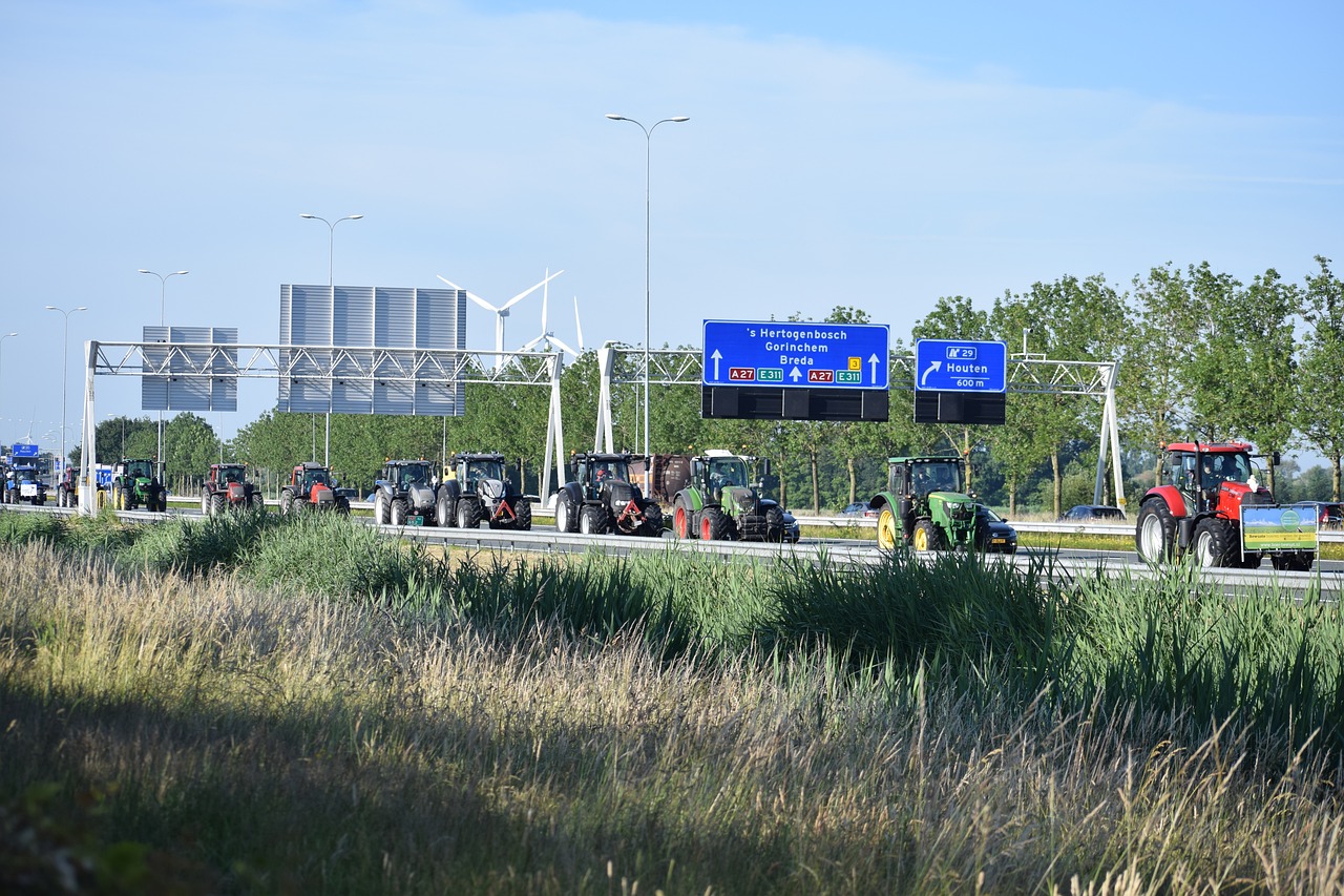 Rund ein Dutzend Traktoren fahren auf einer Autobahn und blockieren dadurch eine Spur.