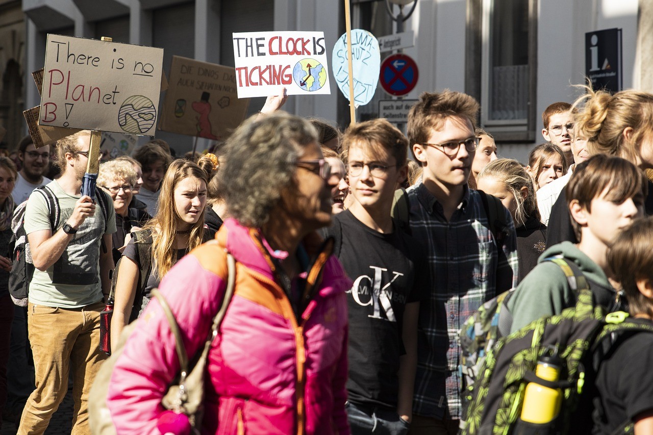 Eine Gruppe von Menschen demonstriert für mehr Klimaschutz mit Plakaten auf denen steht "There is no planet B" und "The clock is ticking"