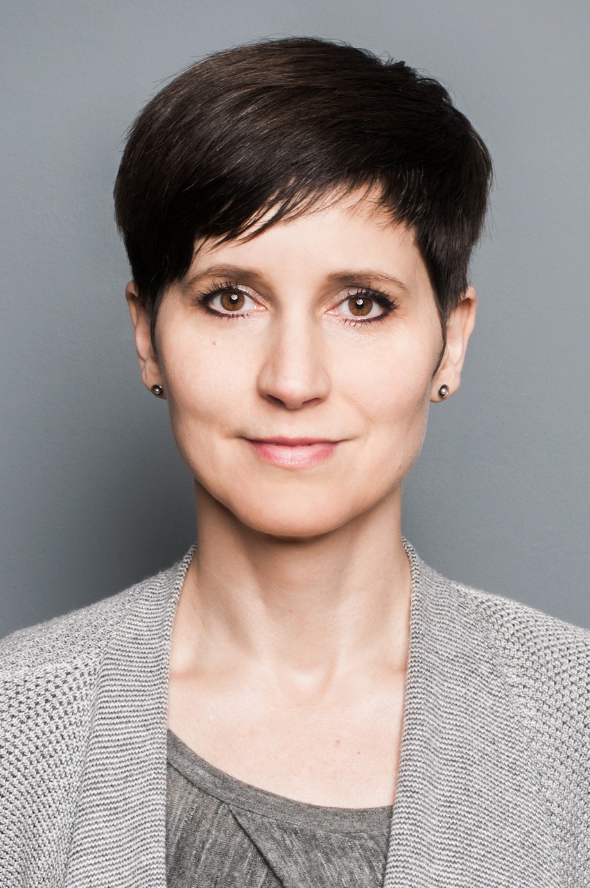 Porträtbild einer Frau mit kurzen brauen Haaren.