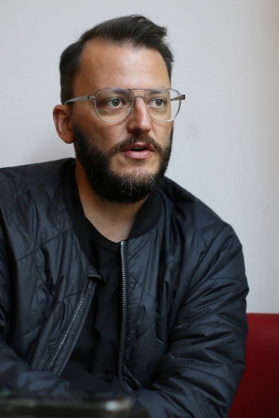 Porträtbild eines Mannes mittleren Alters mit Brille und kurzen braunen Haaren.